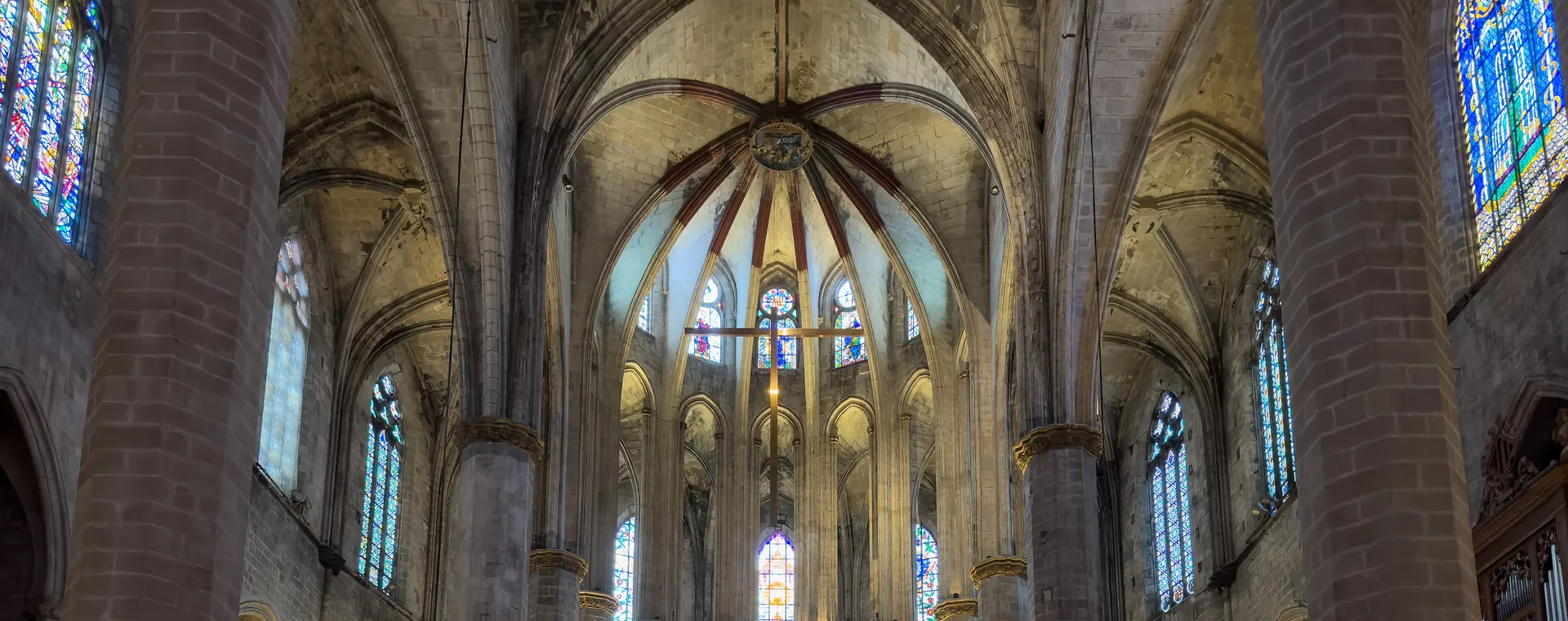 Inside Barcelona's Santa Maria del Mar, slender stone columns rise to a ribbed vault, with stained glass lit from below
